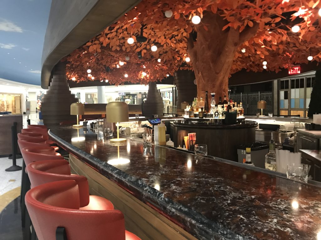 a bar with a tree and chairs