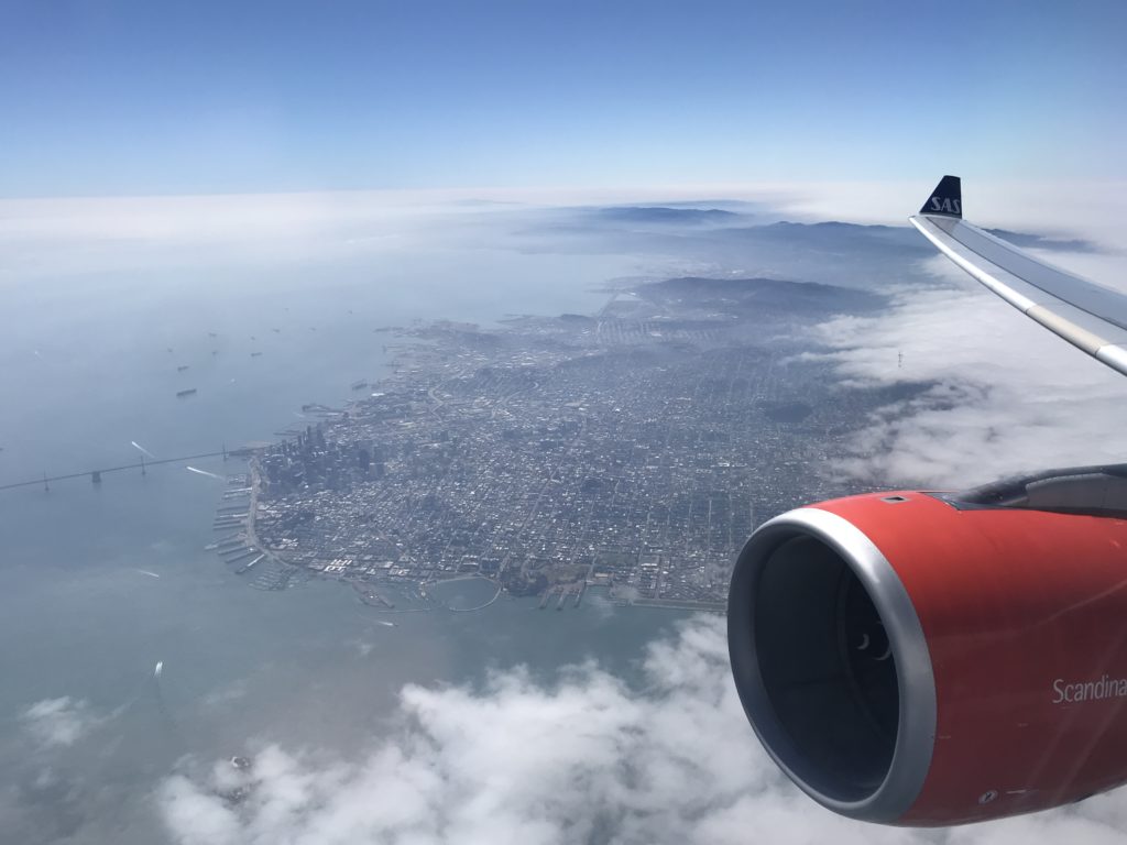 an airplane wing and a city in the sky