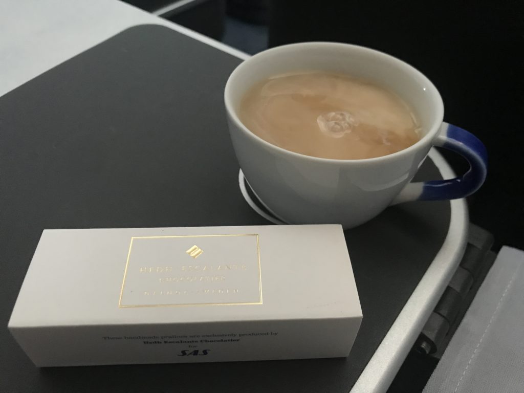 a cup of coffee and a box on a tray