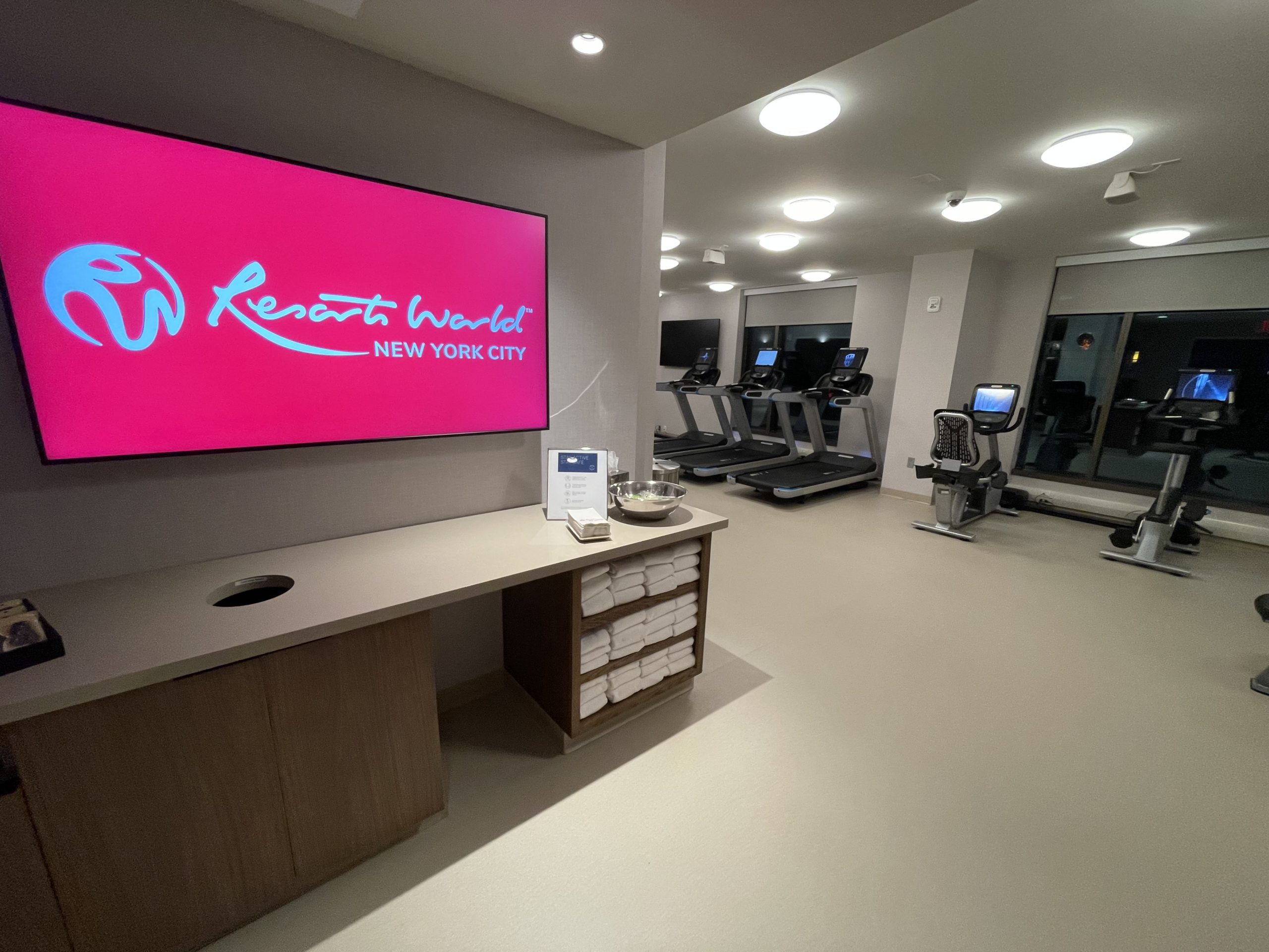 a room with a pink screen and treadmills