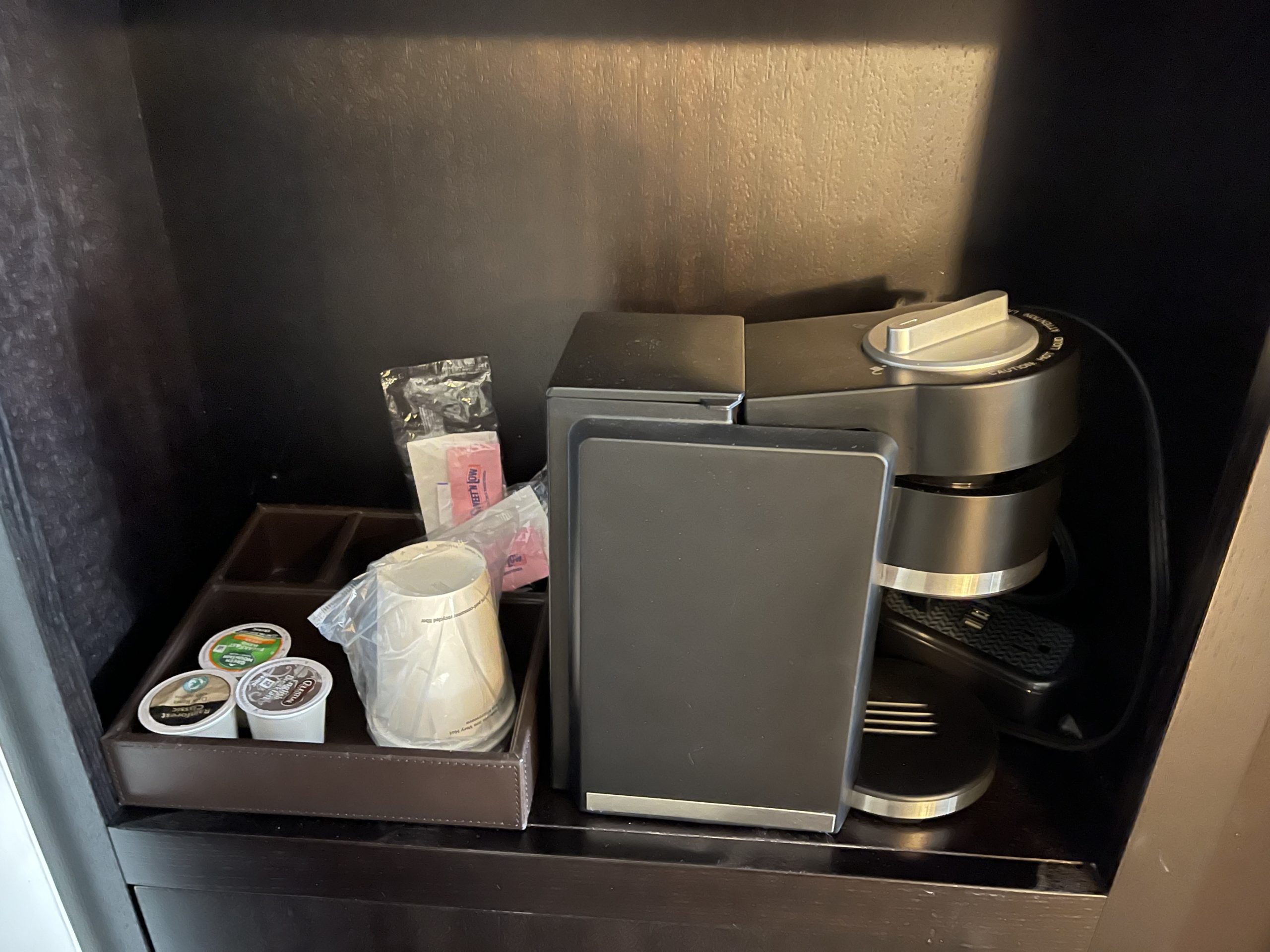 a coffee machine and coffee cups on a shelf