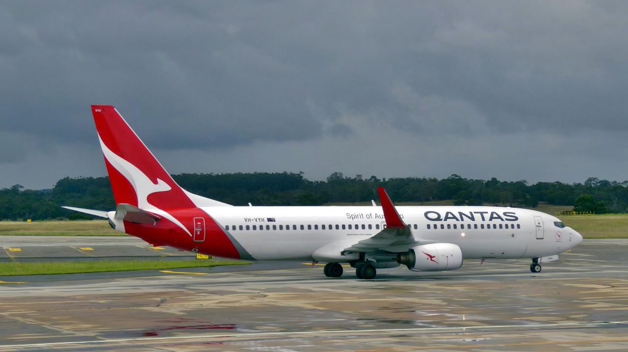 a red and white airplane on a runway