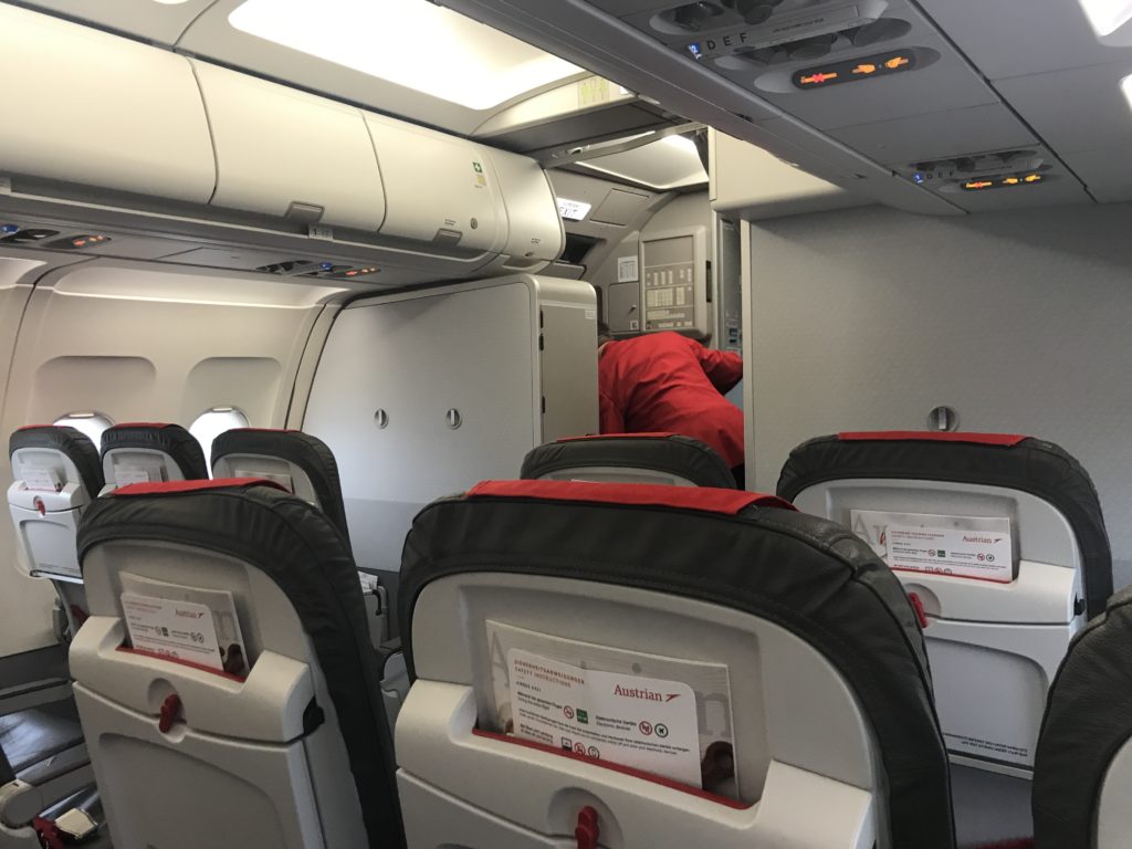 a person in a red and black suit sitting in an airplane