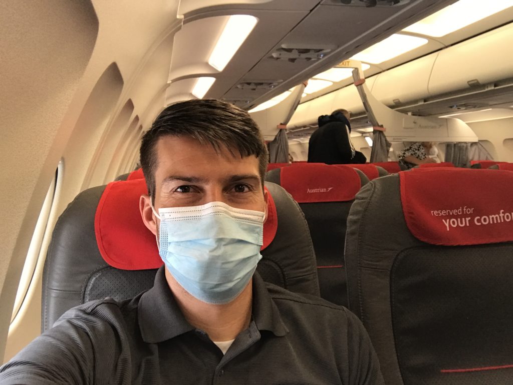 a man wearing a face mask on an airplane
