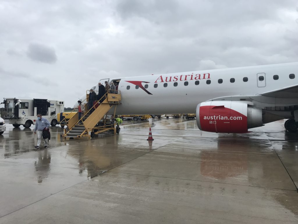 a plane with people boarding stairs