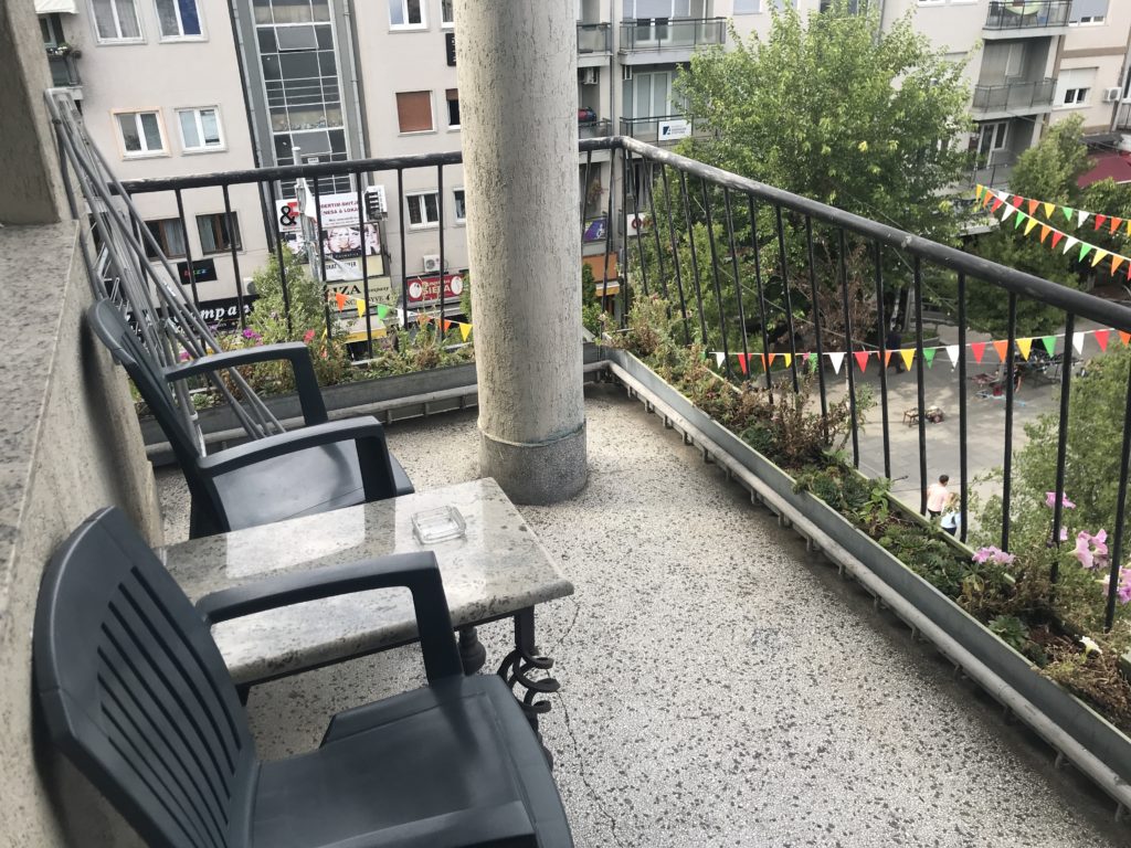 a balcony with chairs and a railing