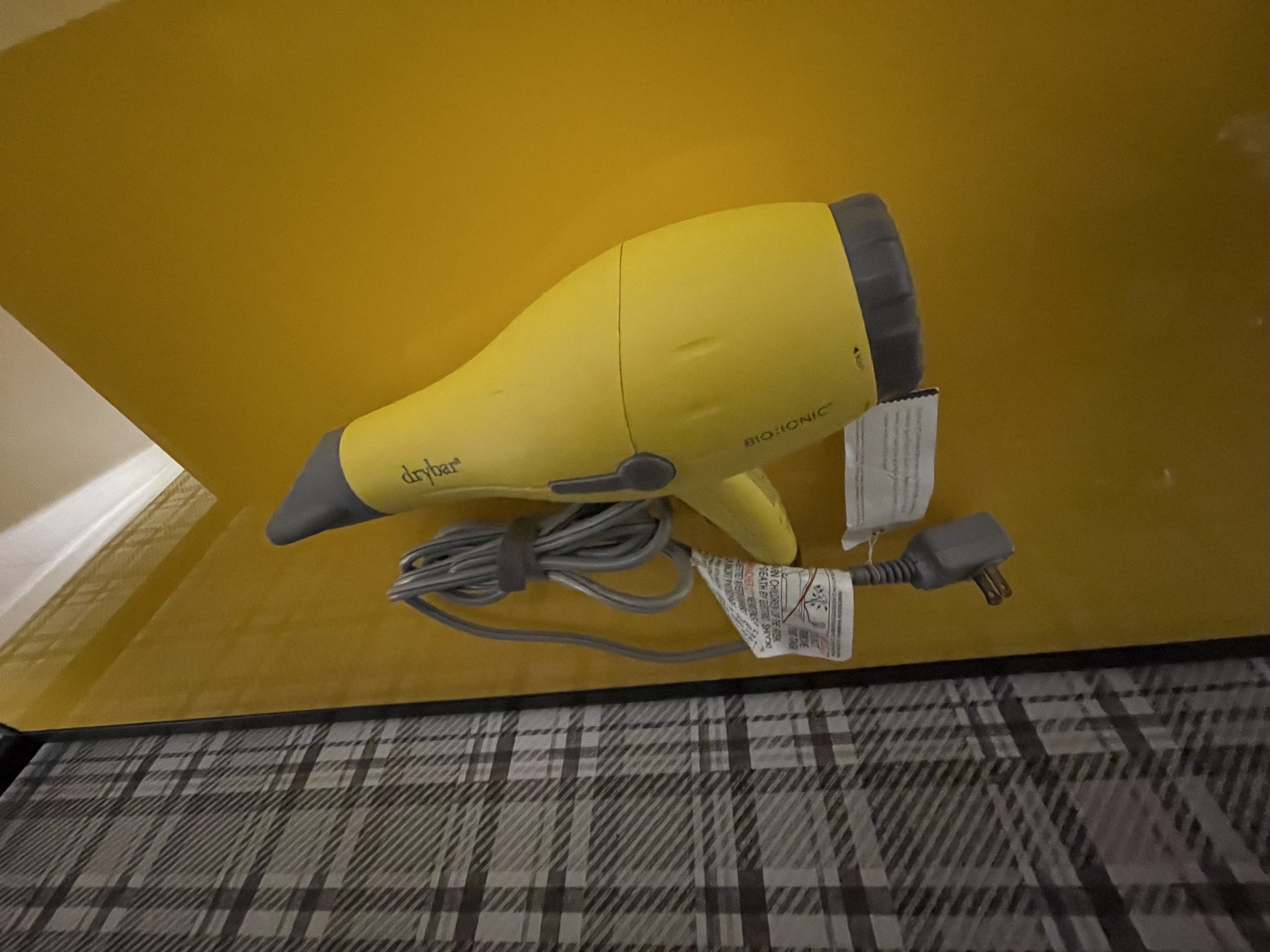 a yellow hair dryer on a yellow wall