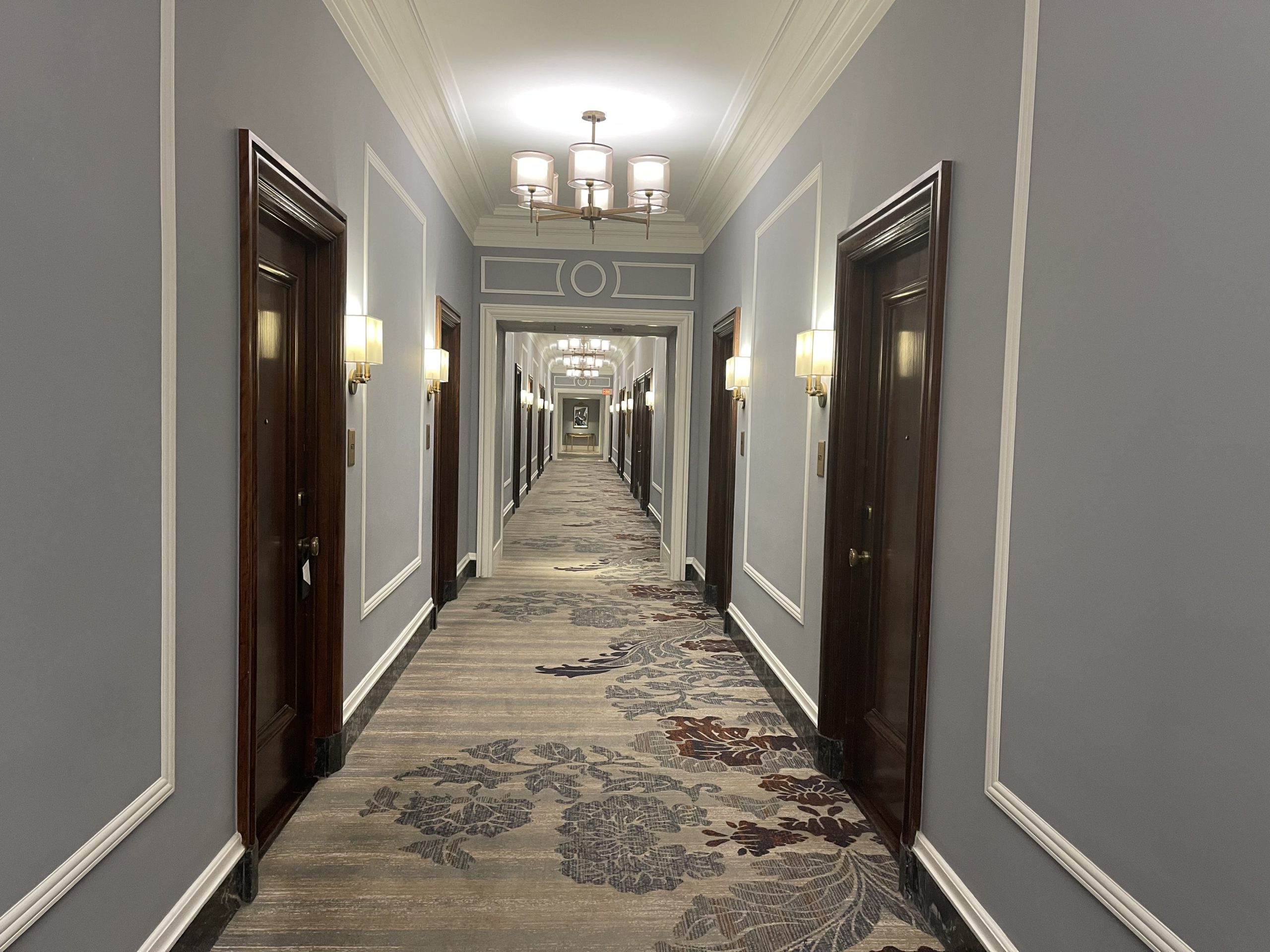 a hallway with doors and a carpeted floor