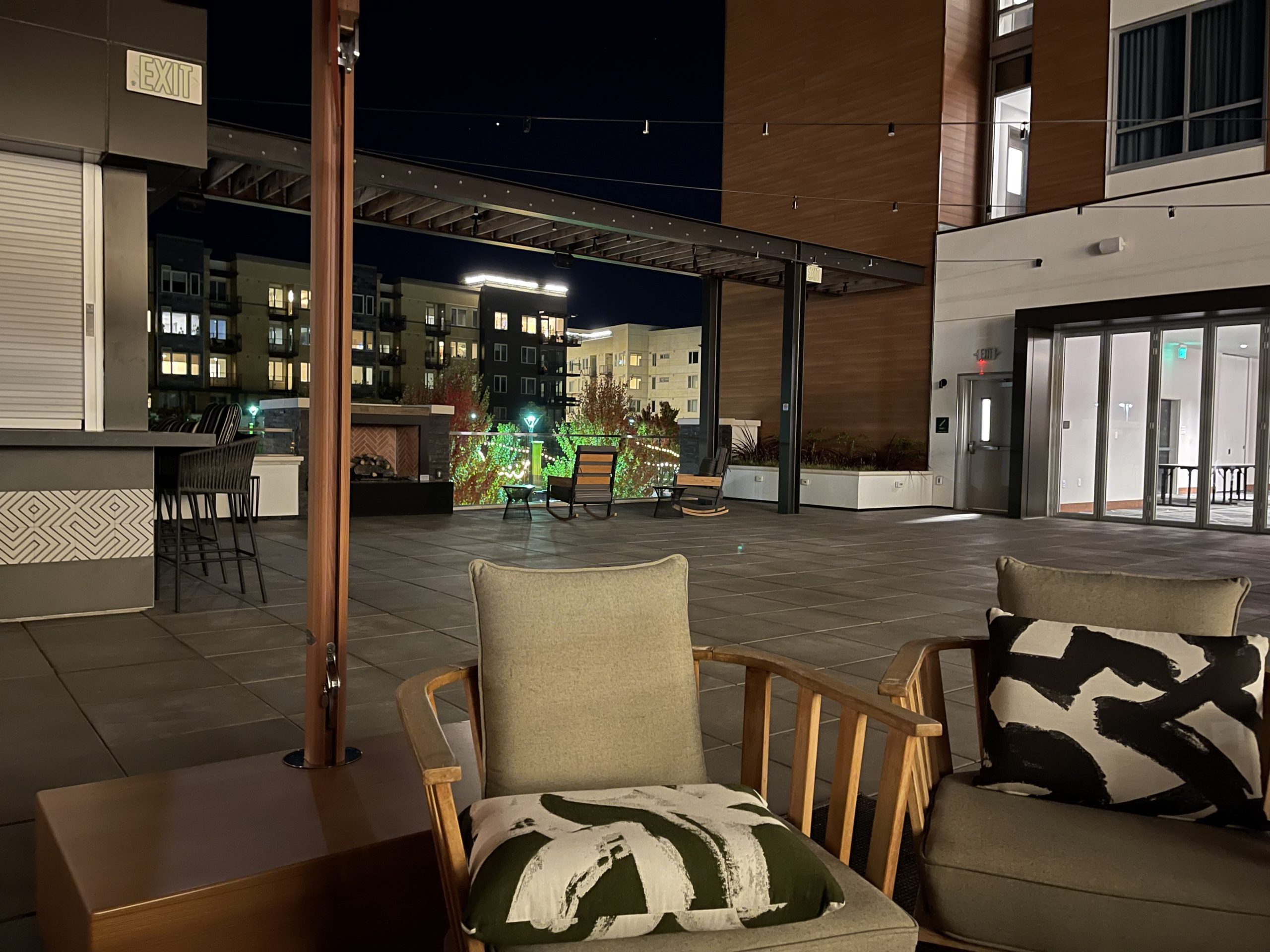 a patio with chairs and a building at night
