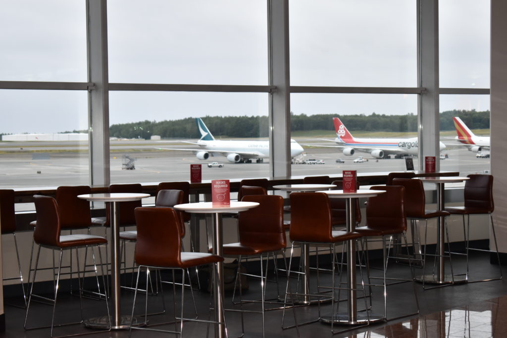 a room with tables and chairs and a plane in the background