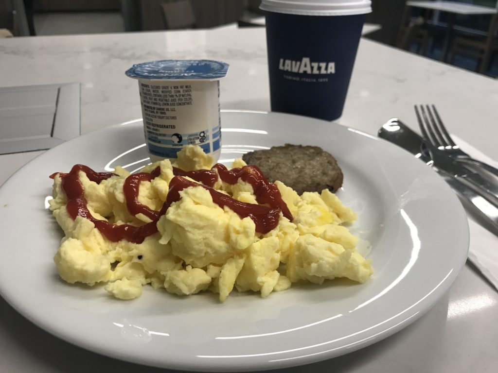 a plate of scrambled eggs and ketchup on a table