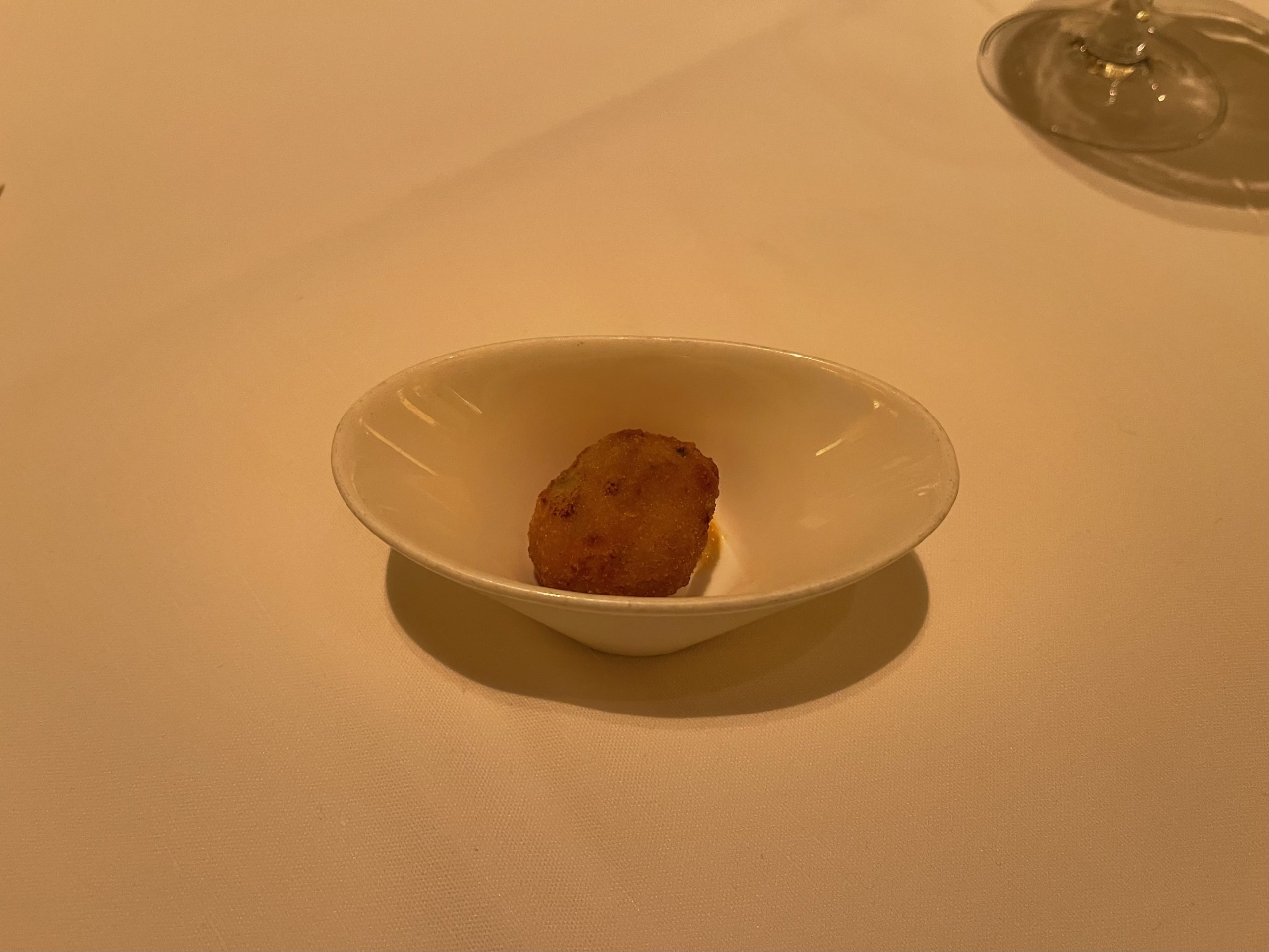 a small white bowl with a piece of food on it