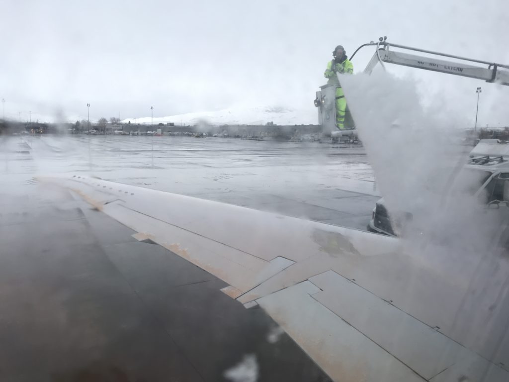 a person spraying water on an airplane wing