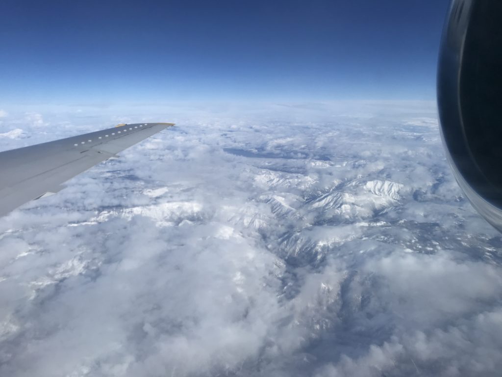 an airplane wing and a view of the mountains