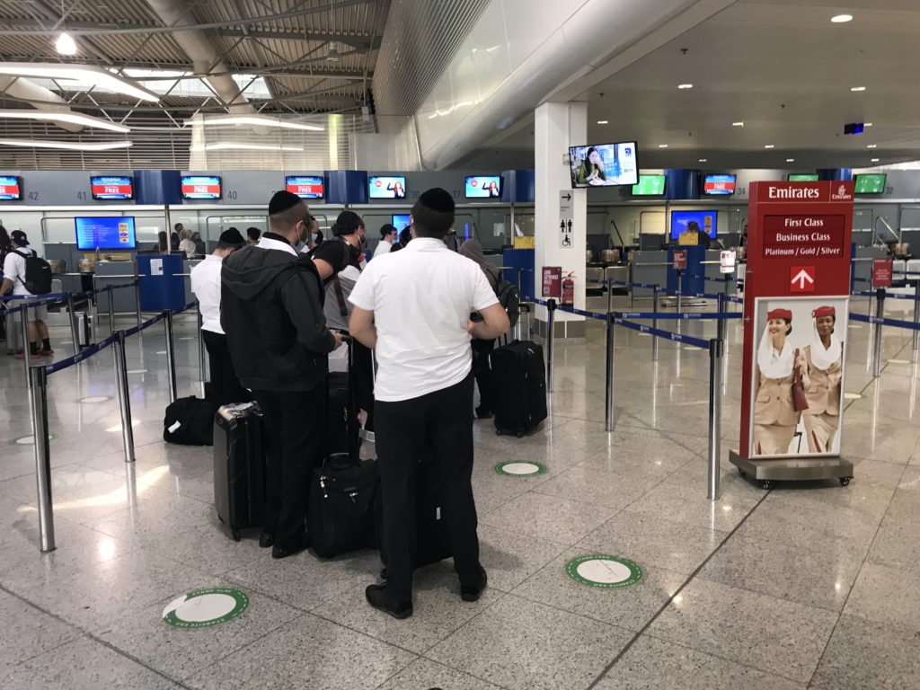 a group of people standing in a line with luggage