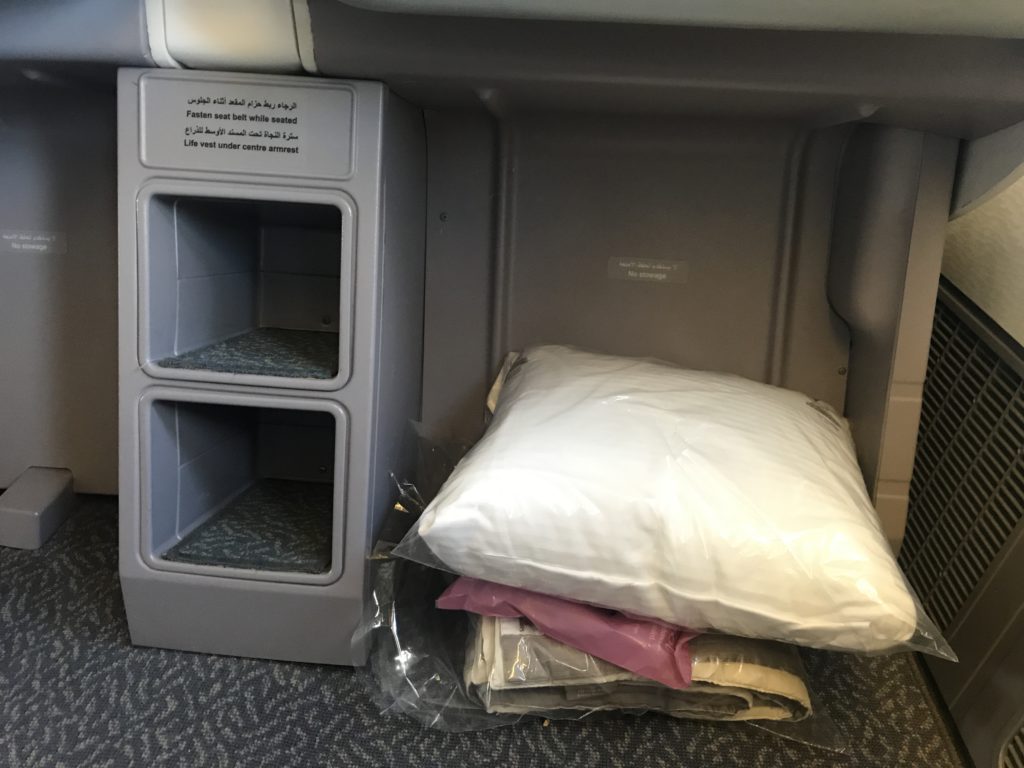 a white pillow and a plastic bag on a grey carpet