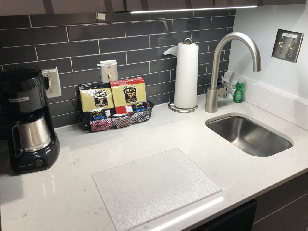 a kitchen counter with a sink and a coffee maker