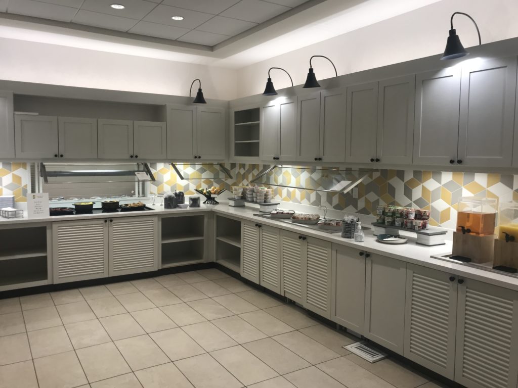 a kitchen with white cabinets and a yellow and white tile floor