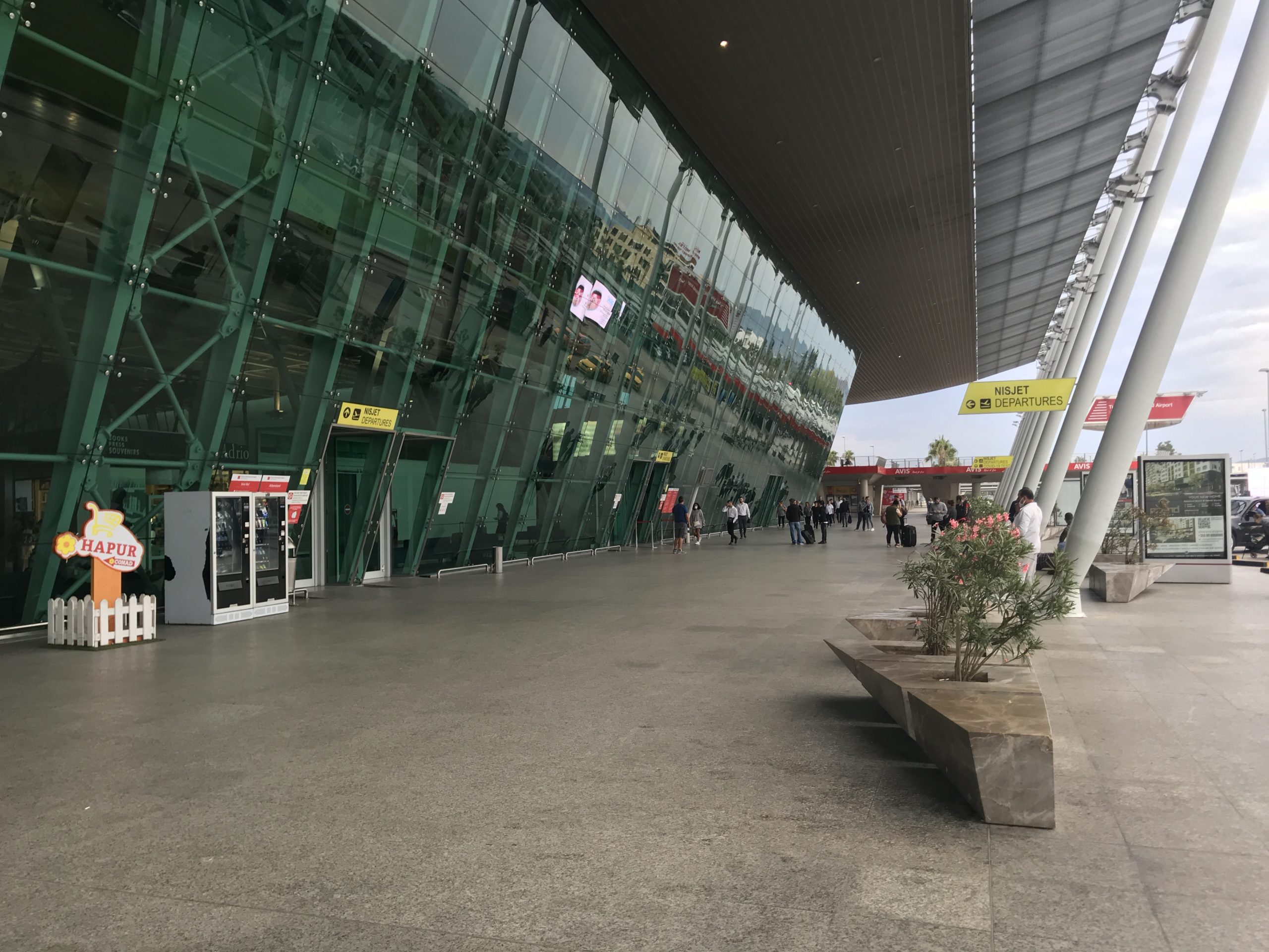 a building with glass walls and people walking