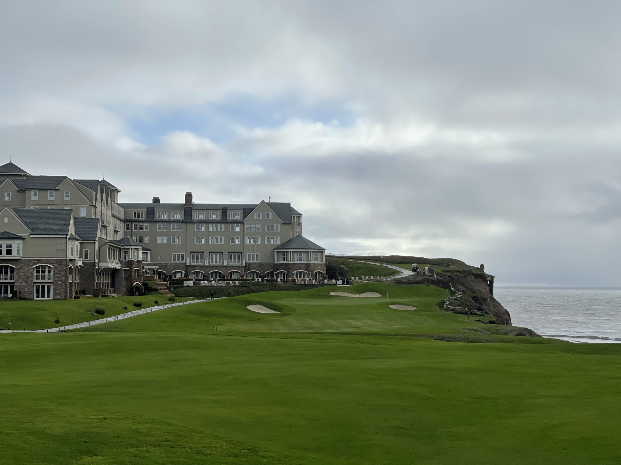 a large building with a golf course and a body of water