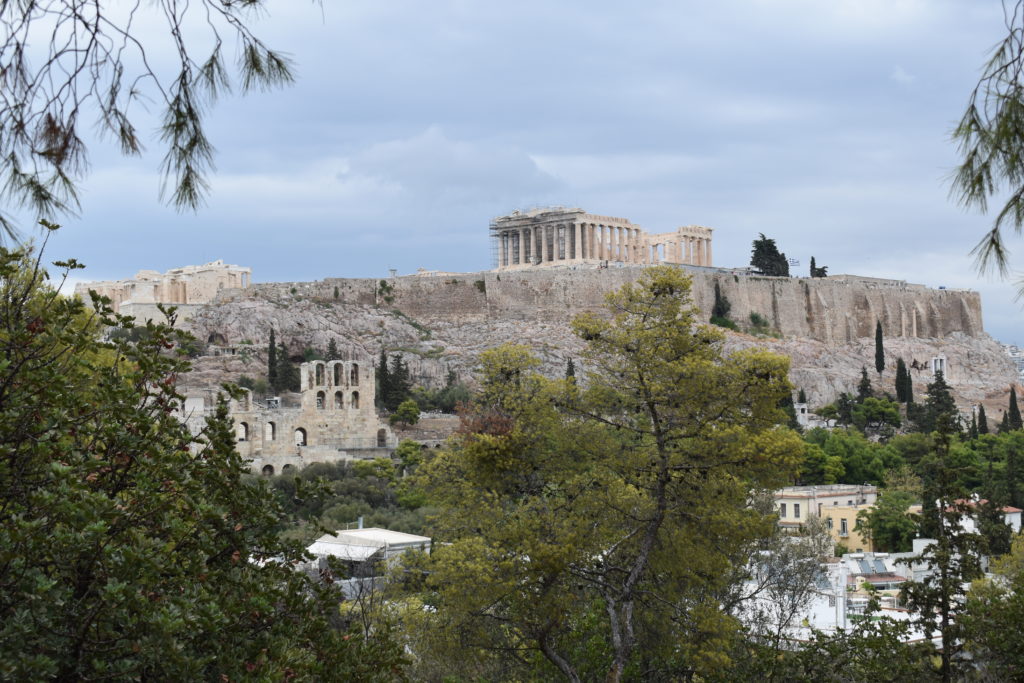 a stone structure on a hill with trees in the background