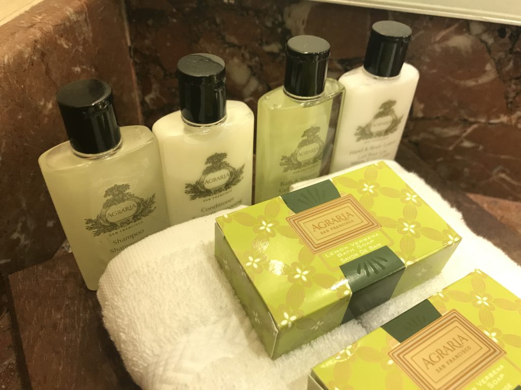 a group of bottles of shampoo and soap on a towel