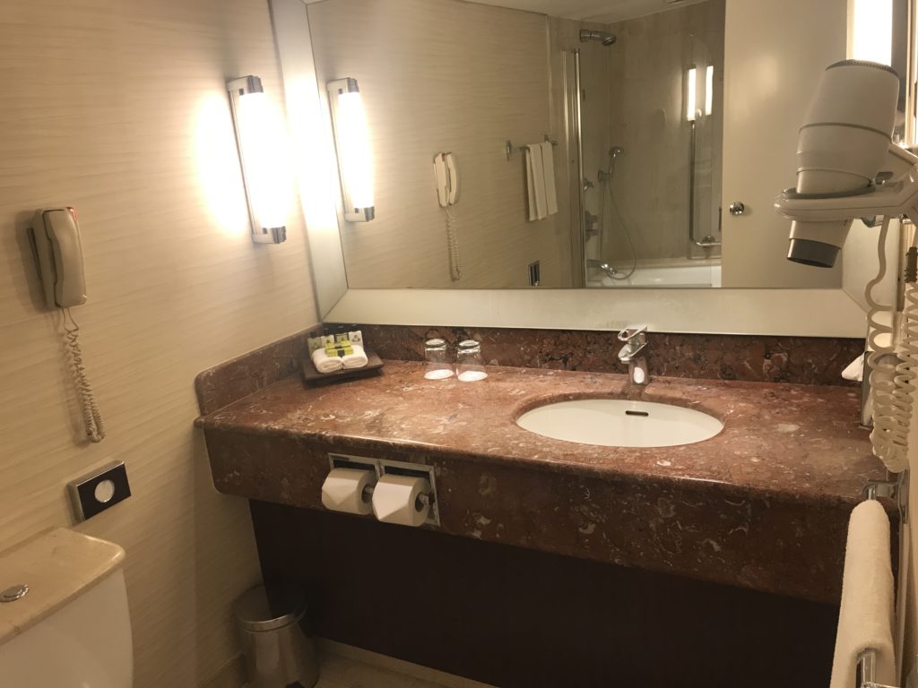 a bathroom with a marble countertop and a mirror