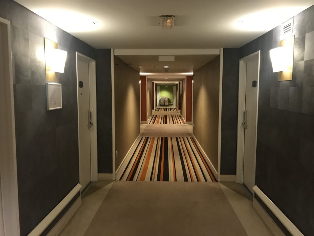 a hallway with doors and a striped carpet