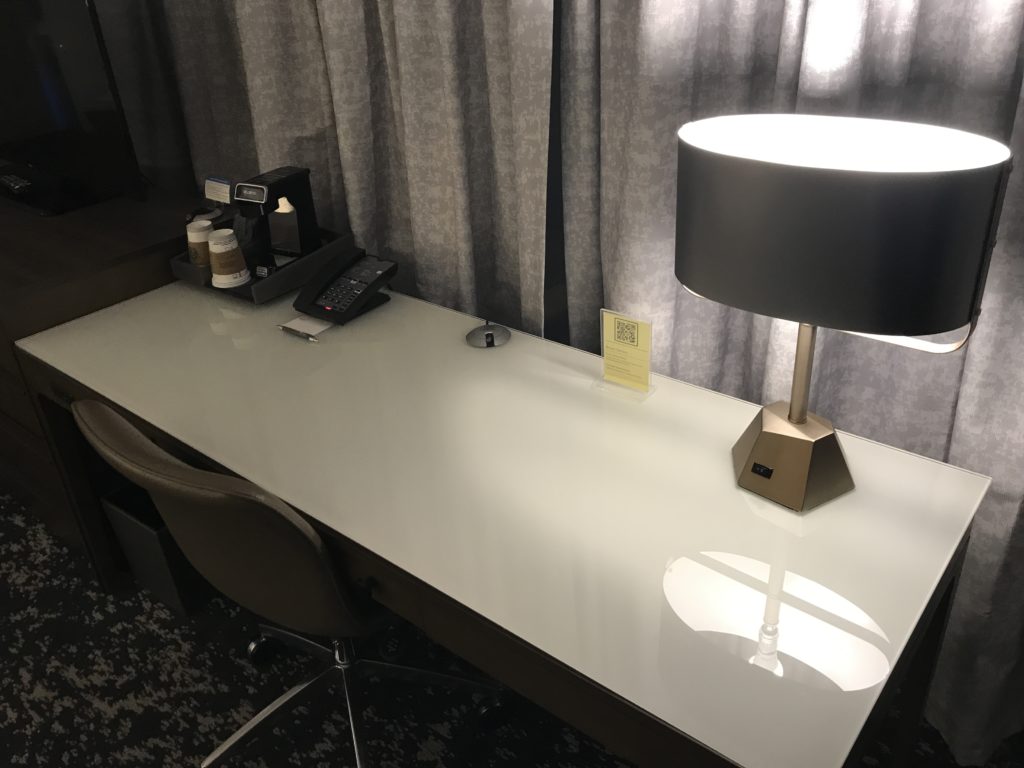 a desk with a lamp and a phone on it