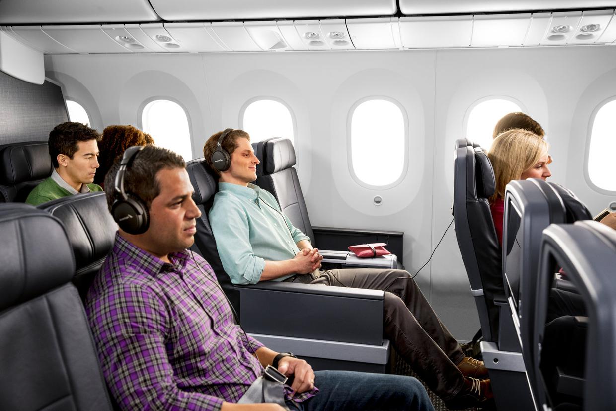 people sitting in an airplane with headphones on