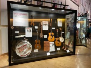 a display case with guitars and drums