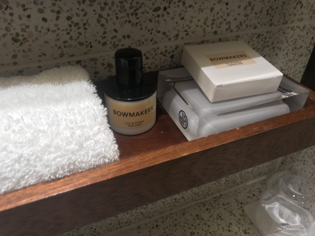 a shelf with a towel and a bottle of perfume