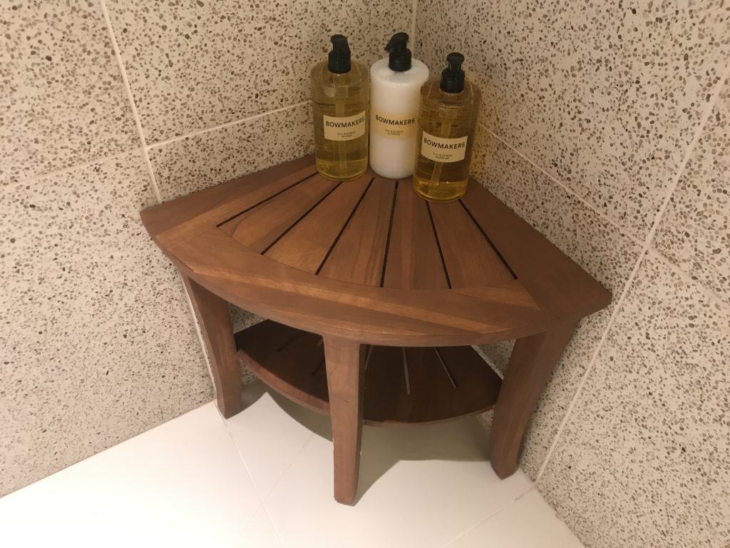 a corner shelf with bottles of liquid on it