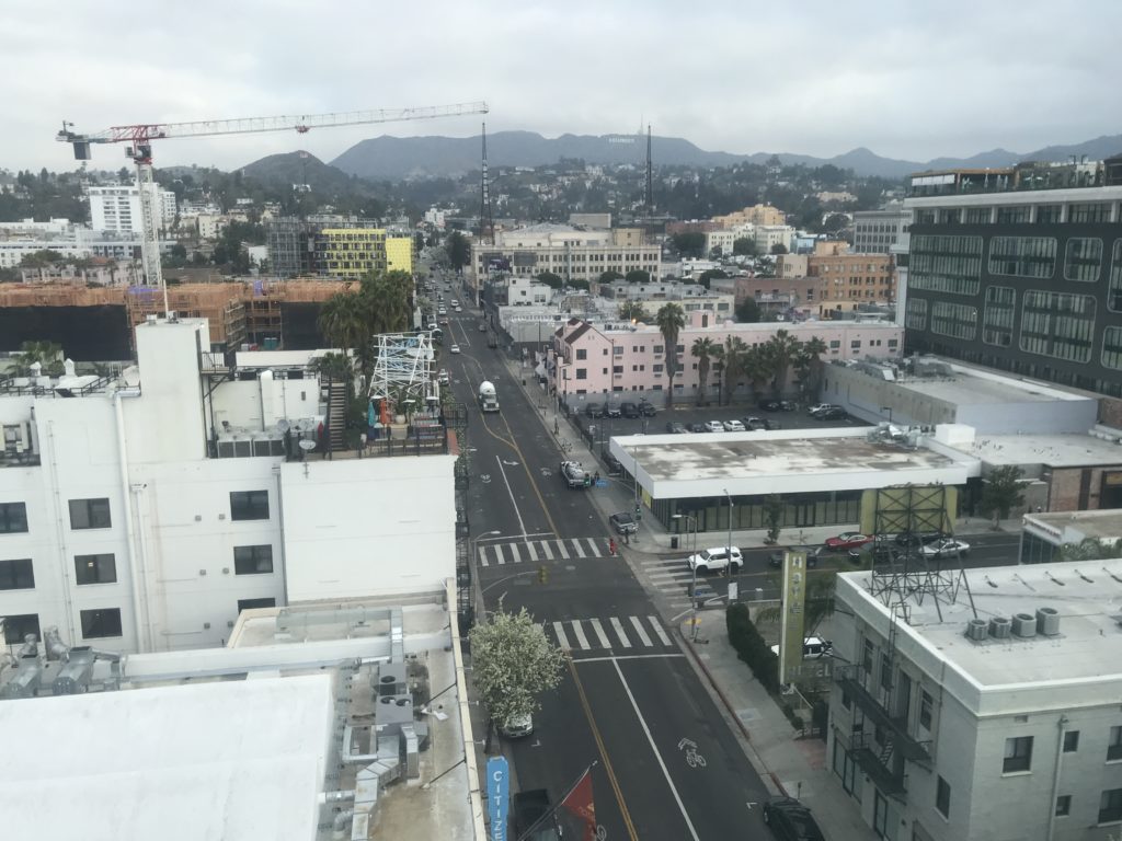 a city street with buildings and a crane