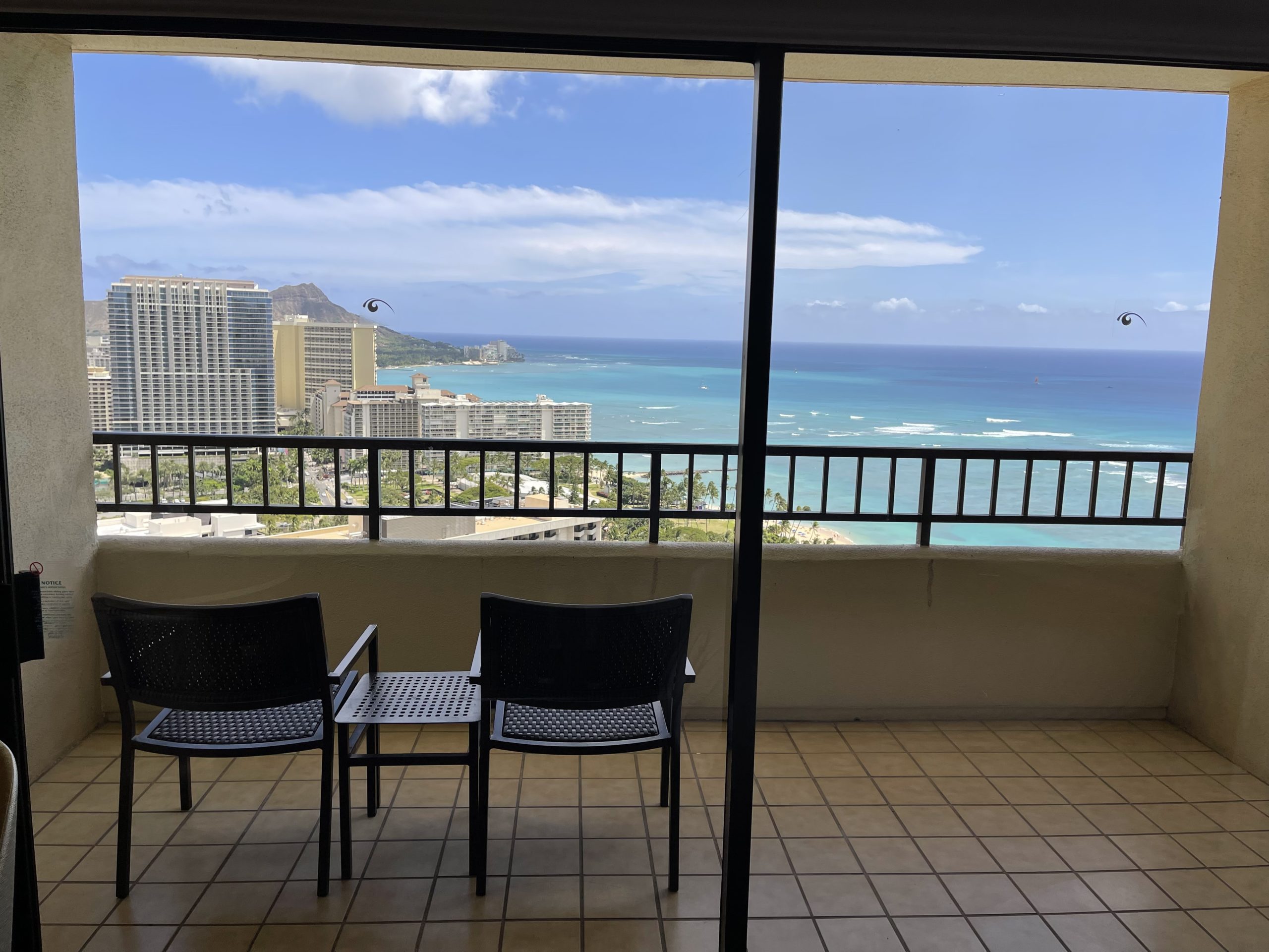 a balcony with chairs and a view of the ocean