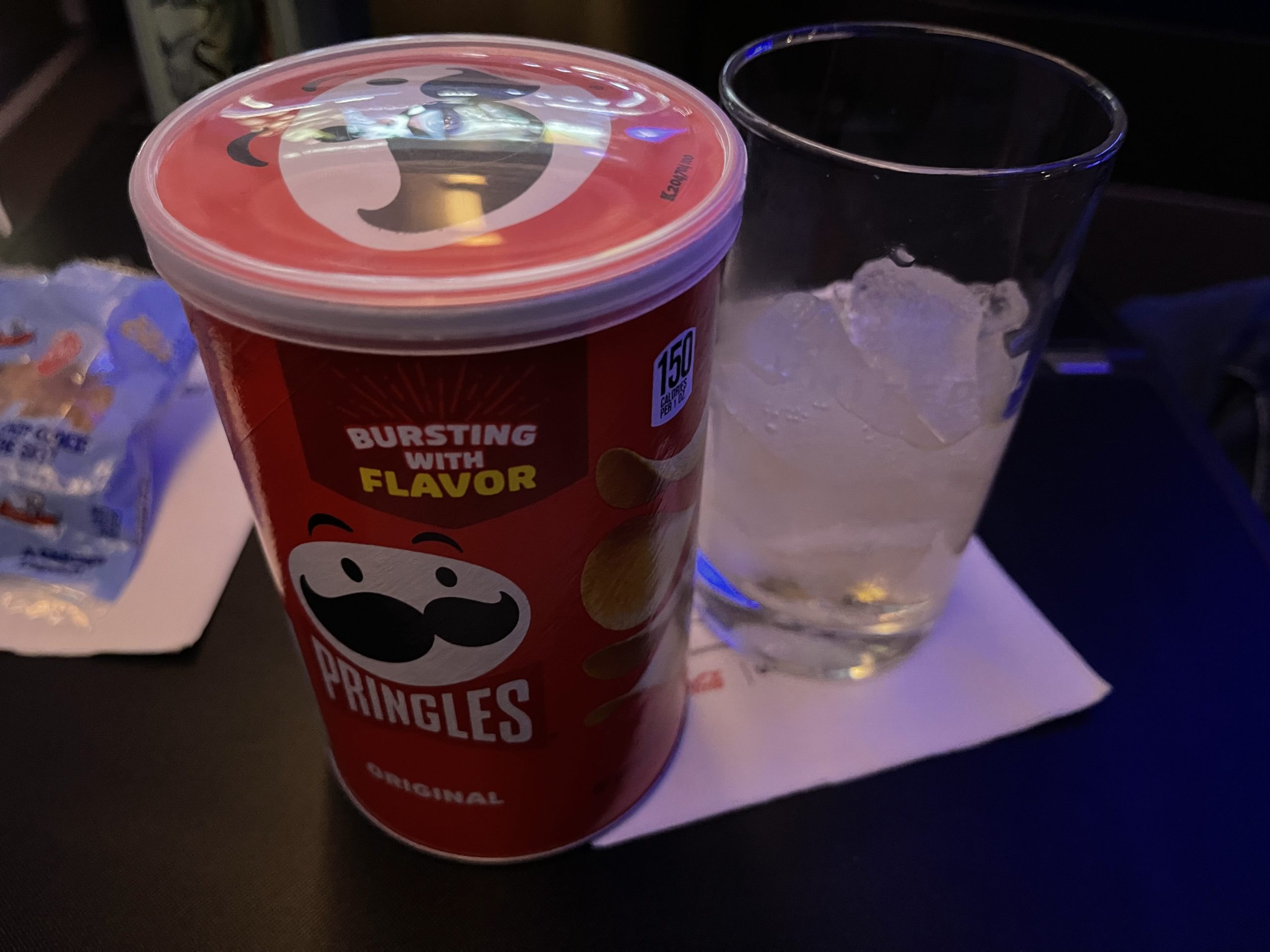 a container of potato chips next to a glass of ice