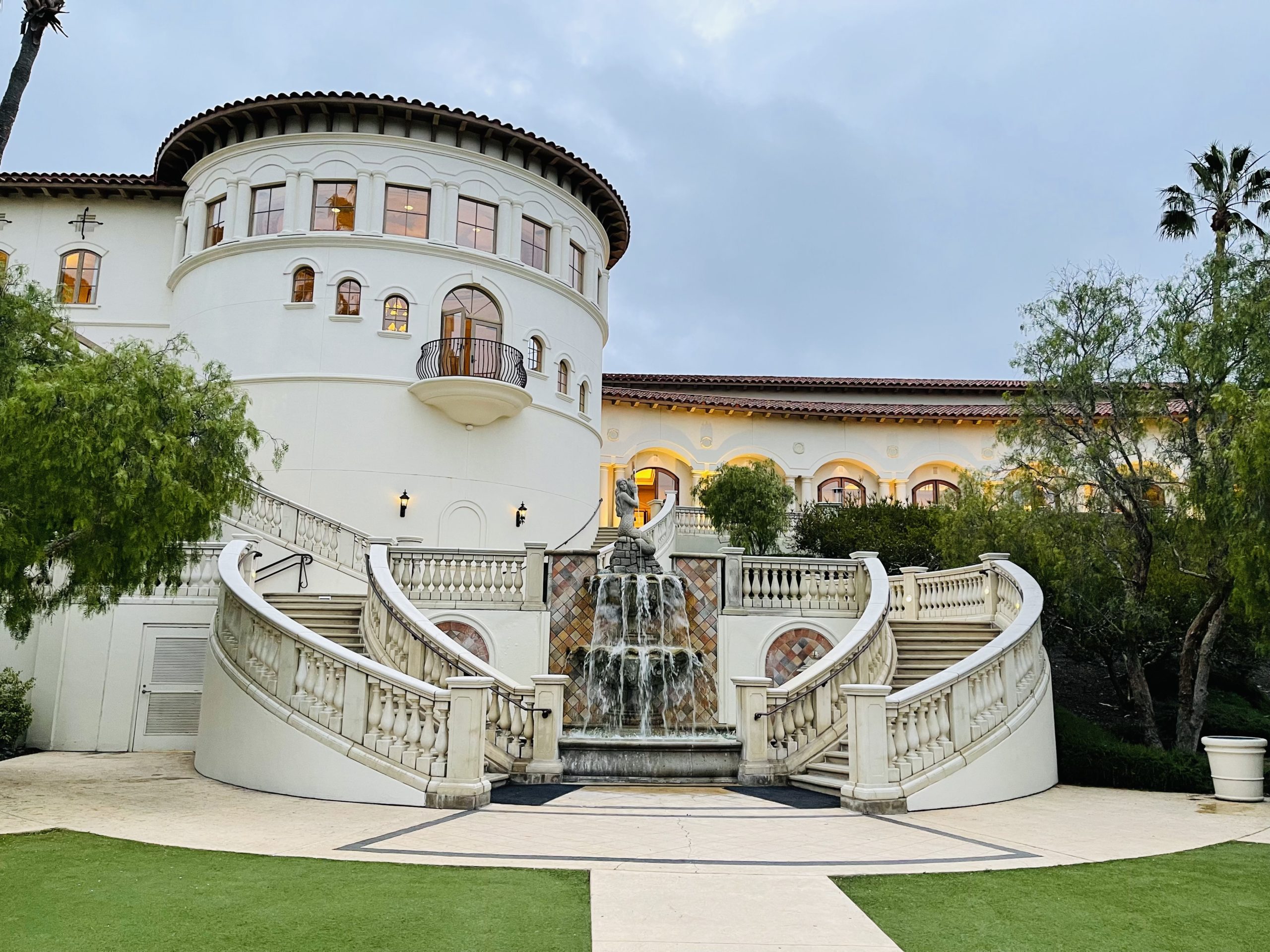 a building with a fountain and grass