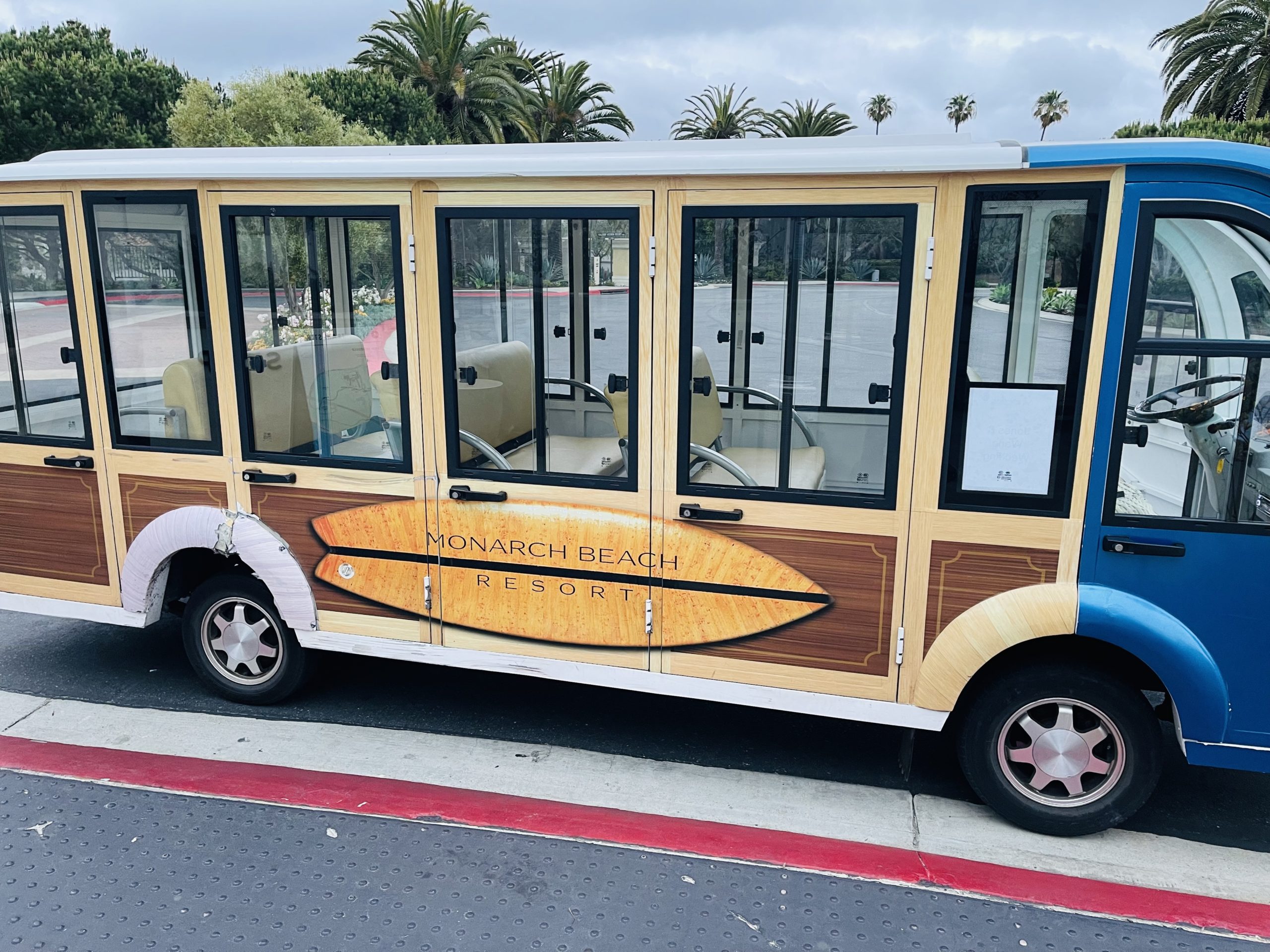 a blue and white bus with a surfboard painted on it