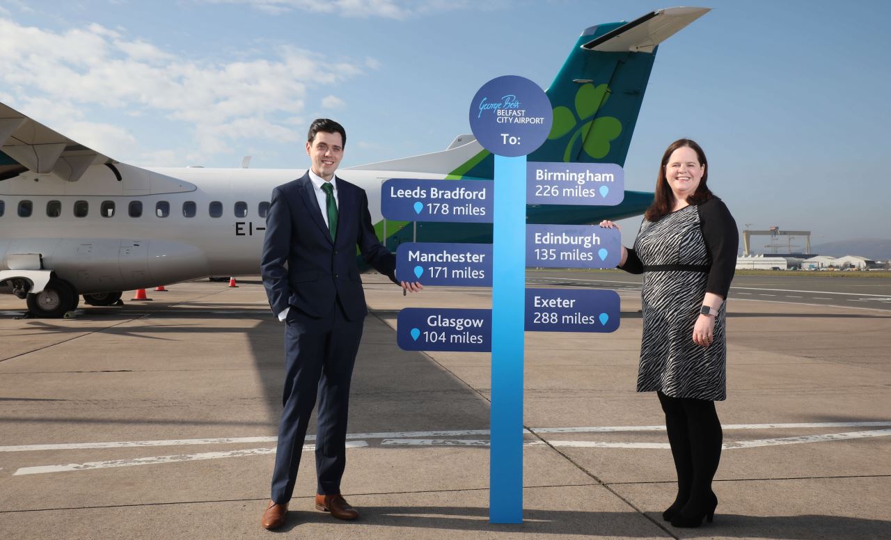 a man and woman standing in front of a sign