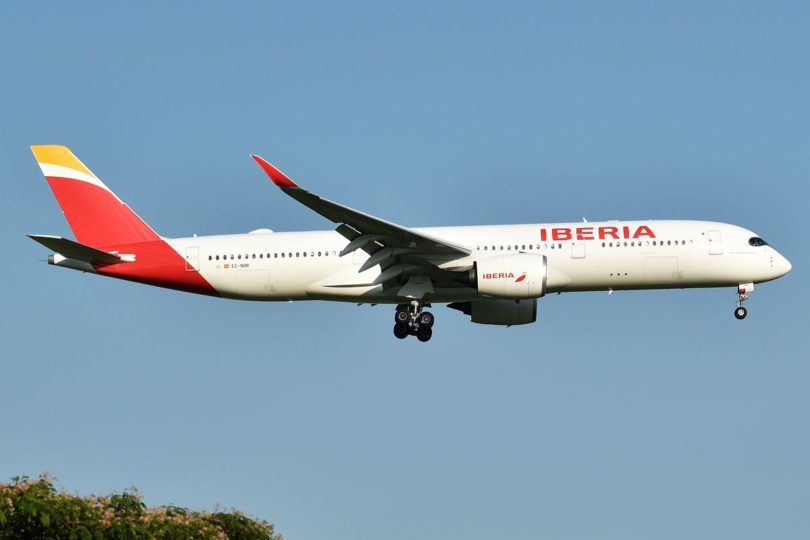 a white and red airplane flying in the sky