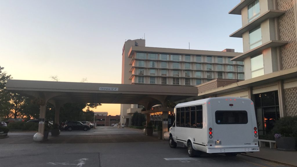 a white bus parked in front of a building