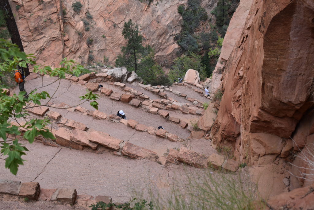 a group of people walking down a rocky mountain