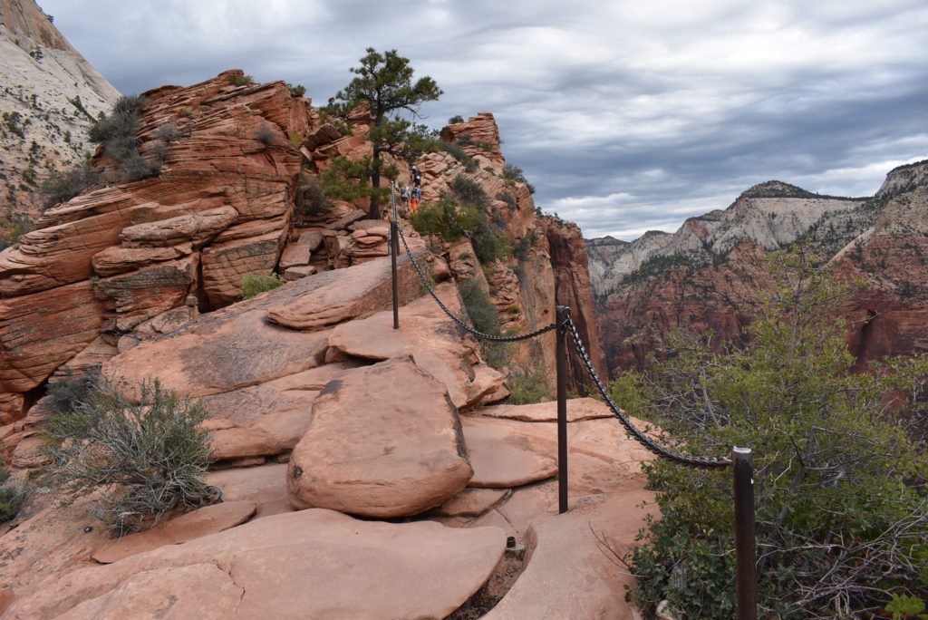 a trail with a chain on a rocky cliff