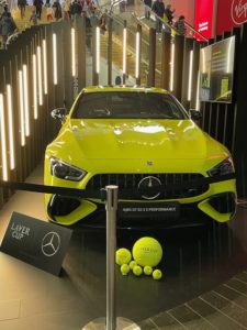 a yellow sports car with tennis balls on a black floor