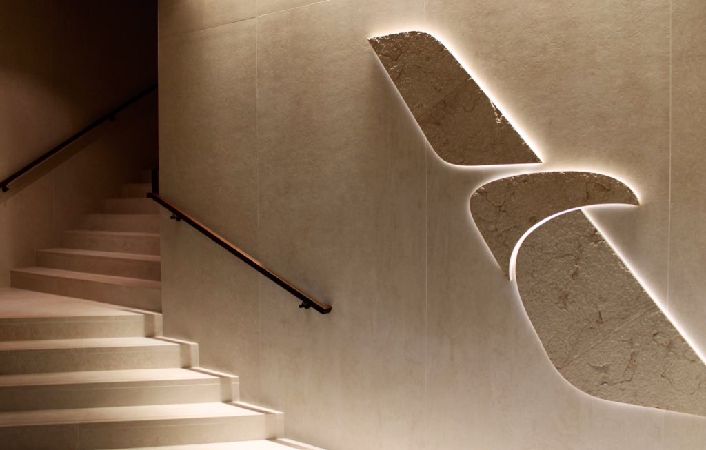 The entrance to the new Admirals Club at Washington National Airport featuring an illuminated stone American Airlines flight symbol.