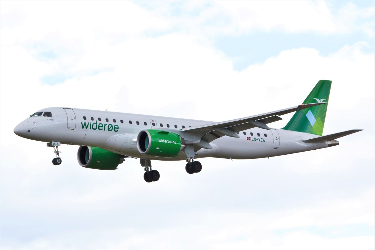 a white and green airplane flying in the sky