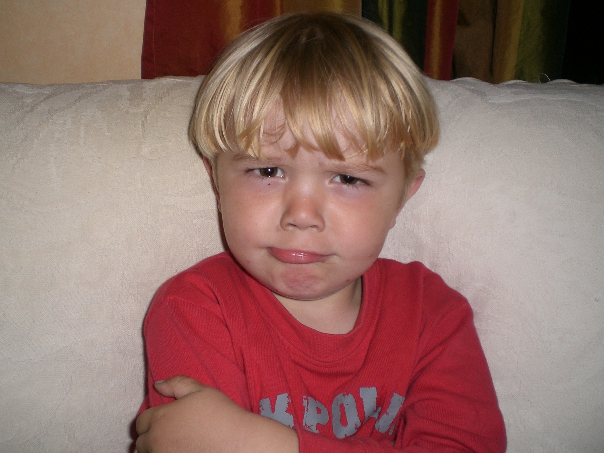 a boy sitting on a couch making a face