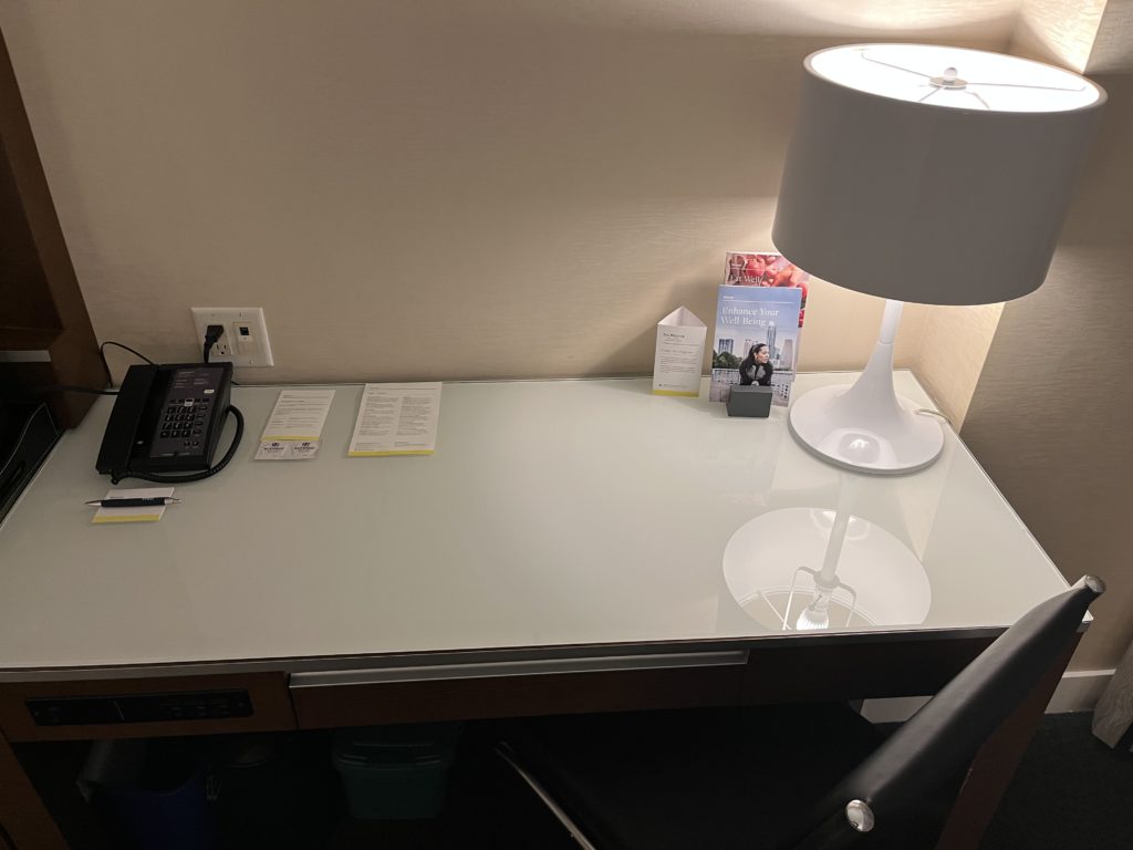 a desk with a lamp and telephone