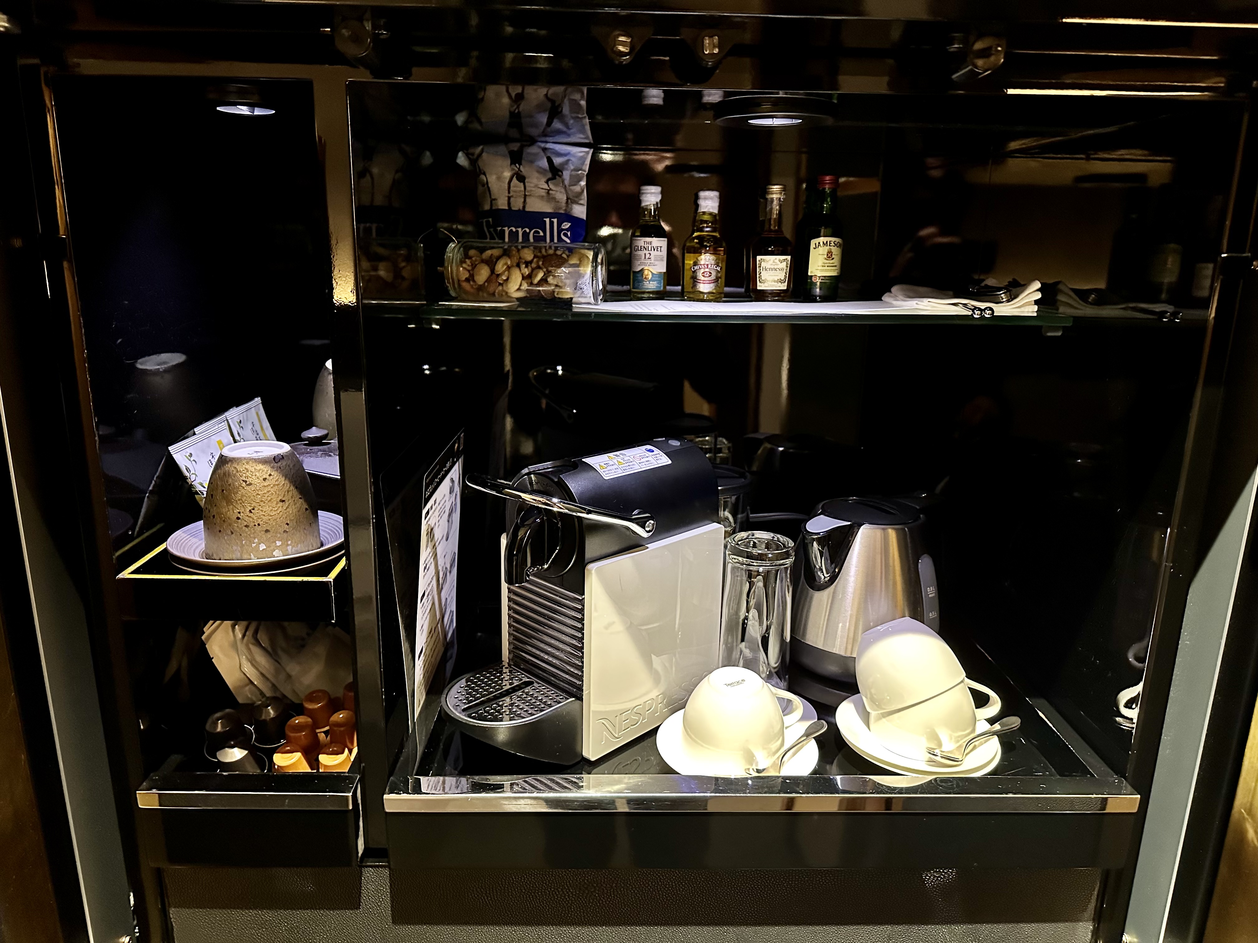 a coffee machine and cups on a shelf