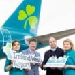 a group of people holding signs in front of an airplane